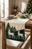 Runner natalizio Deer Clodette color panna con cervi, abeti verdi e stelle, steso su una tavola in legno.
