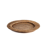 Sottopiatto tondo H&H in rattan naturale, con bordo rialzato intrecciato e centro traforato, vista obliqua.